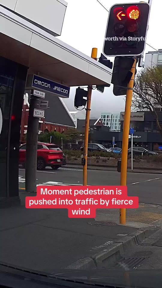 This is the moment a person was facing a fierce wind pushing